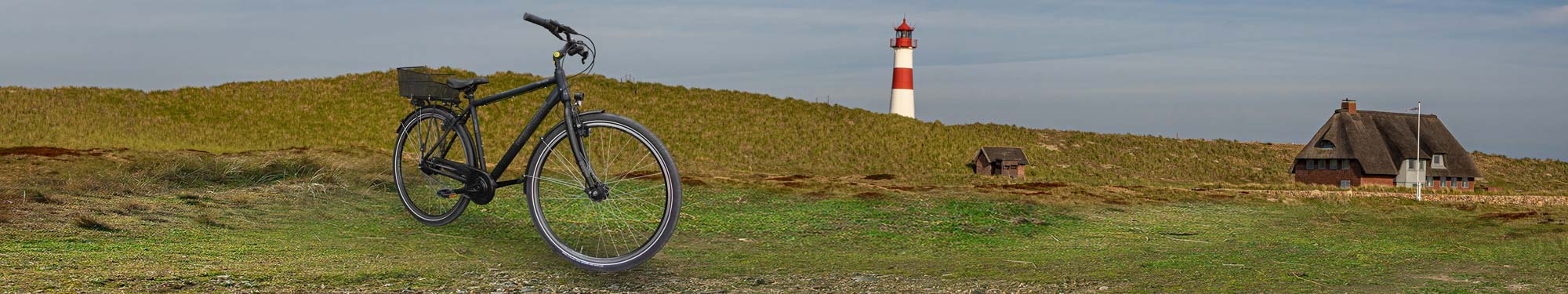 Trekkingbike vor Dünen mit Leuchtturm auf Sylt